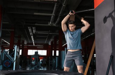 Spor salonunda lastik ile sportif genç adam eğitimi