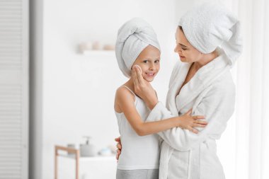 Anne banyo onun küçük kızı yüzüne losyon uygulayarak