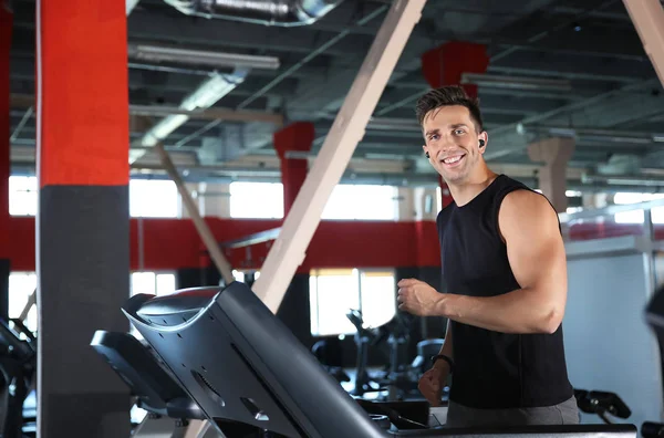 Sporty young man training on treadmill in gym — Stock Photo, Image