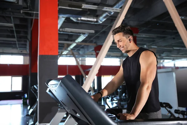 Sportiga unga mannen utbildning på löpbandet i gymmet — Stockfoto