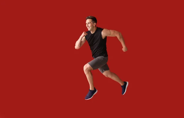 Bieganie młody człowiek na tle kolorów — Zdjęcie stockowe