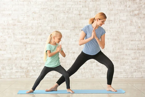 Madre con bambina che fa yoga al chiuso — Foto Stock