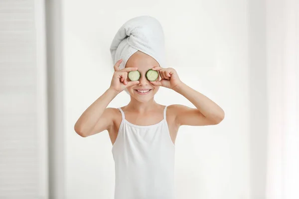 Banyoda salatalık dilimleri ile gözler kapsayan sevimli küçük kız — Stok fotoğraf