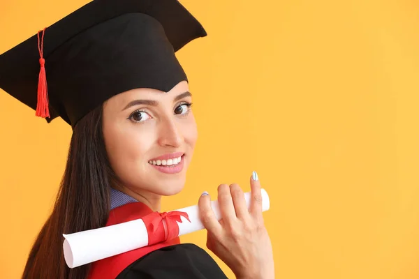 Female graduate with diploma on color background — Stock Photo, Image