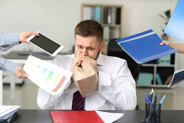 Overworked businessman having panic attack in office