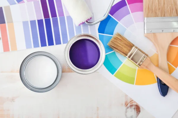 Cans of paint with supplies and palette samples on light background — Stock Photo, Image