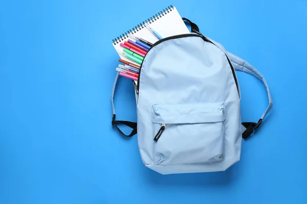 Mochila escolar con papelería sobre fondo de color —  Fotos de Stock
