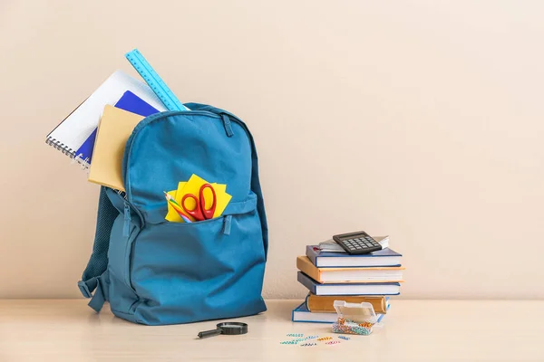 Zaino scuola con cancelleria sul tavolo sullo sfondo chiaro — Foto Stock