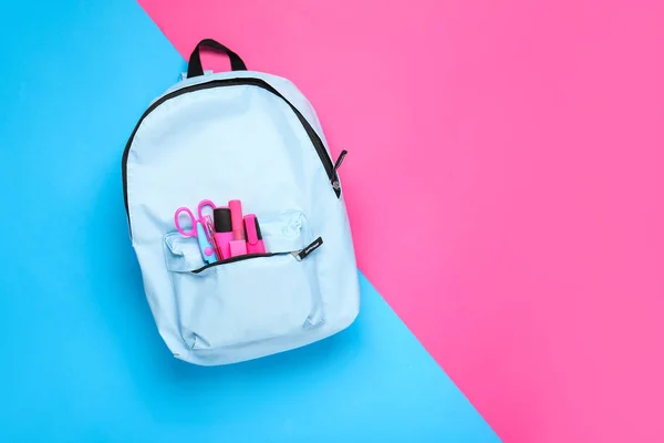 School backpack with stationery on color background — Stock Photo, Image
