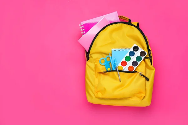 Mochila escolar con papelería sobre fondo de color — Foto de Stock