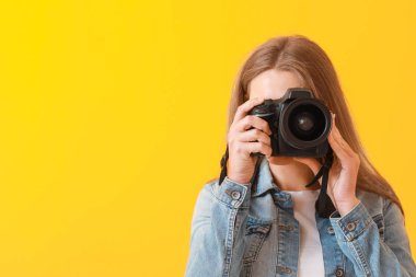 Renkli arka planda genç kadın fotoğrafçı