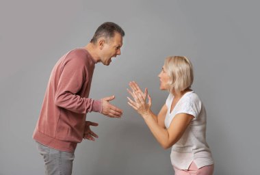 Gri arka planda orta yaşlı çift mücadele