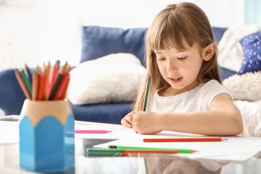 Evde çizim yapan küçük tatlı bir kız.
