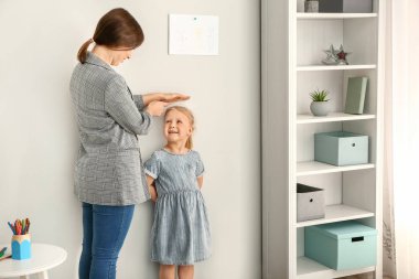 Anne duvar yakın küçük kız yüksekliği ölçme