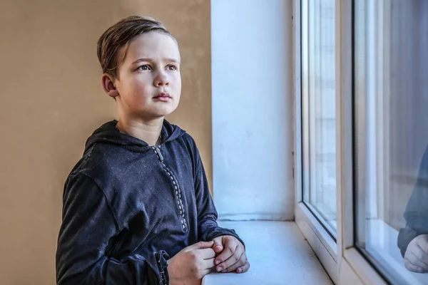 Бездомный маленький мальчик у окна — стоковое фото