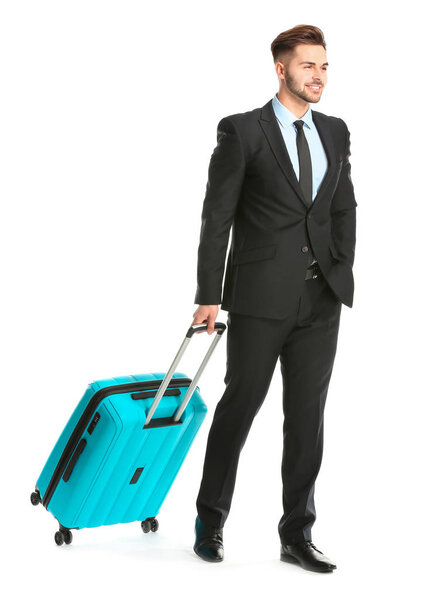 Handsome young businessman with luggage on white background