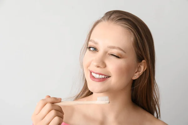 Happy woman with toothbrush on light background — Stock Photo, Image