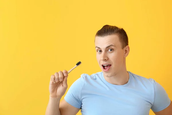 Hombre feliz con cepillo de dientes sobre fondo de color —  Fotos de Stock