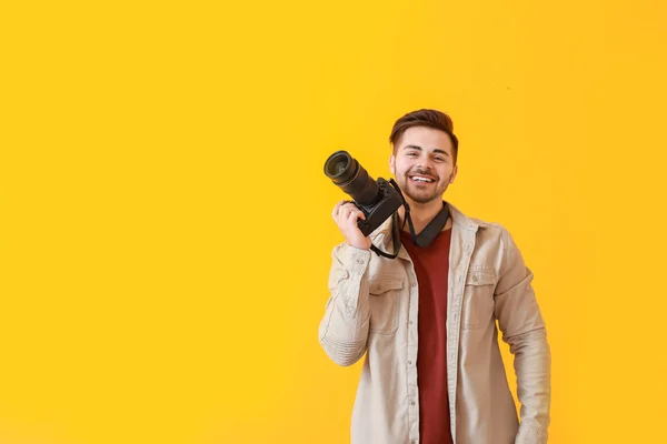 Young male photographer on color background — Stock Photo, Image