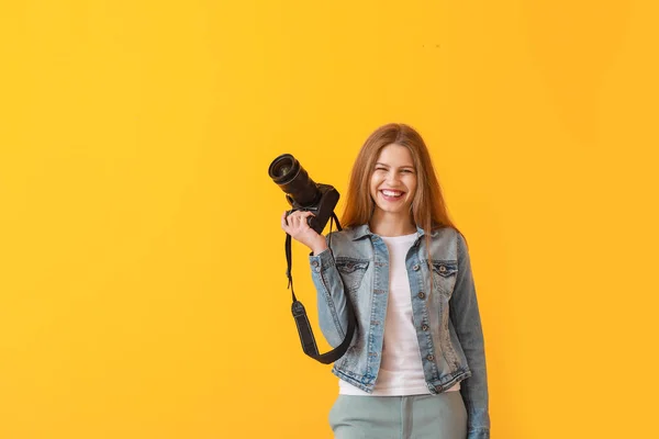 Young female photographer on color background — Stock Photo, Image