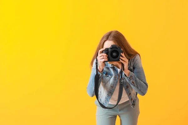 Młoda kobieta fotograf na kolorowym tle — Zdjęcie stockowe