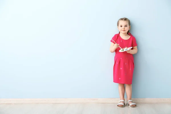 Hafif duvara yakın fırça ve palet ile küçük kız — Stok fotoğraf