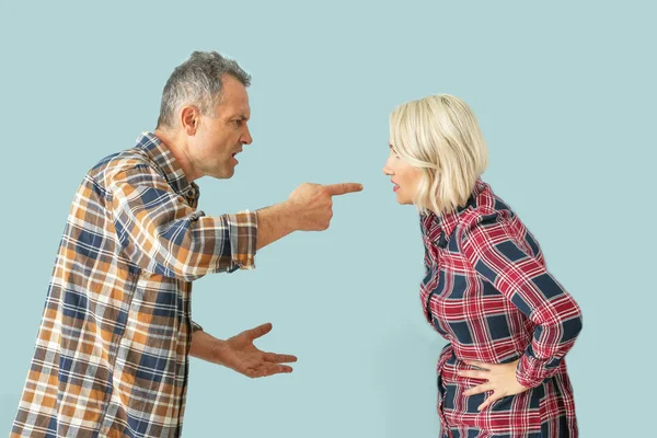 Quarrelling middle-aged couple on color background — Stock Photo, Image