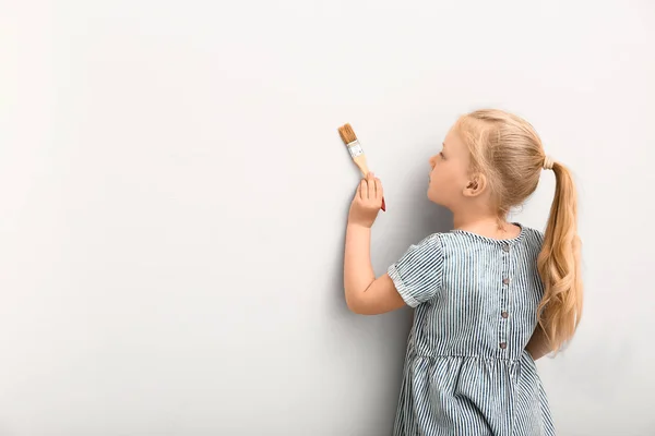 Маленькая девочка рисует на стене — стоковое фото