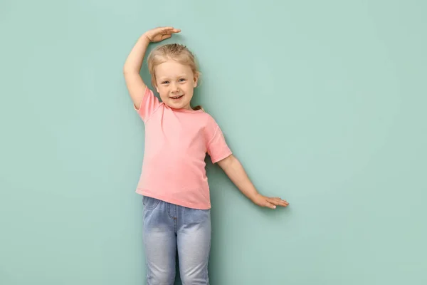 Little girl measuring height near wall — Stock Photo, Image