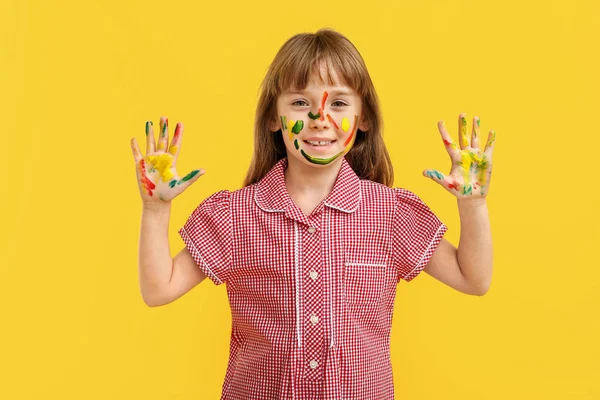 Funny little girl with hands and face in paint on color background — Stock Photo, Image