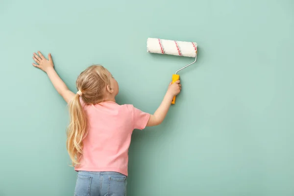 Маленькая девочка рисует цветную стену — стоковое фото