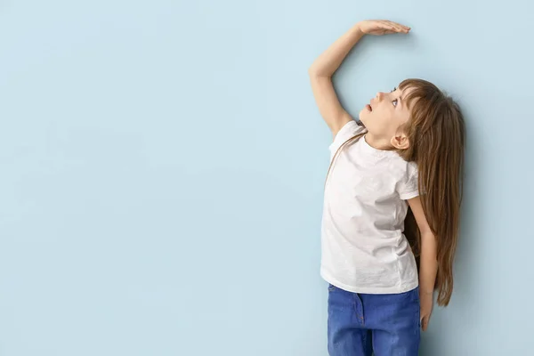 Petite fille mesurant la hauteur près du mur — Photo