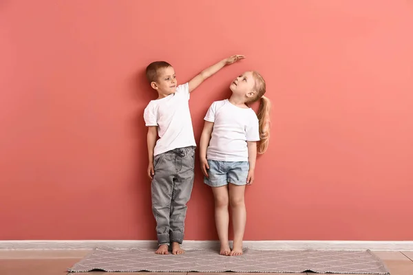 Little children measuring height near wall — Stock Photo, Image