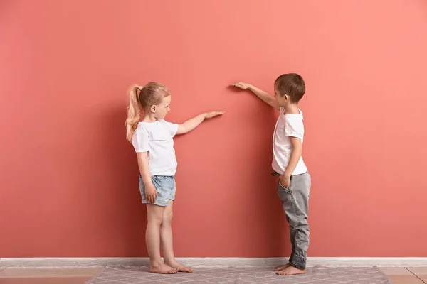 벽 근처의 높이를 측정하는 어린 아이들 — 스톡 사진