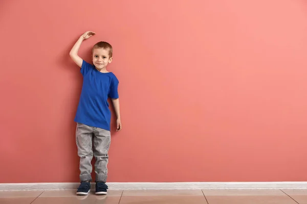 Little boy measuring height near wall — Stock Photo, Image