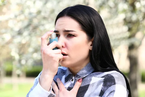 Woman with inhaler having asthma attack on spring day — Stock Photo, Image