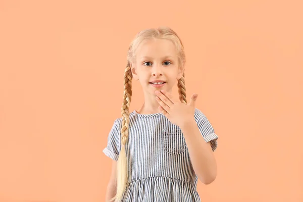 Piccola ragazza sordomuta che usa il linguaggio dei segni su sfondo a colori — Foto Stock