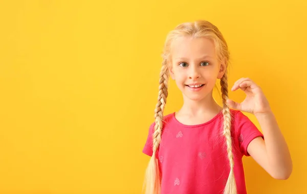 색상 배경에 수화를 사용하여 작은 청각 장애인 음소거 소녀 — 스톡 사진