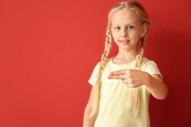 Renk arka plan üzerinde işaret dilini kullanarak küçük sağır dilsiz kız