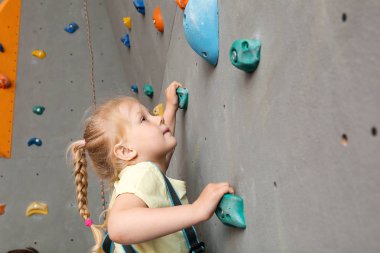 Küçük kız spor salonunda duvar tırmanma