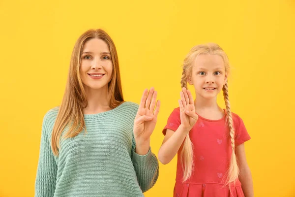 Trochę głuchy dziewczyna niemy i jej matka za pomocą języka migowego na tle kolorów — Zdjęcie stockowe