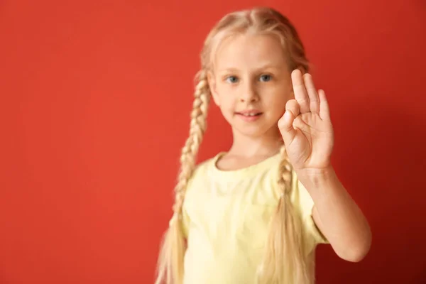 Μικρό κωφό μουγγό κορίτσι χρησιμοποιώντας νοηματική γλώσσα στο χρώμα φόντου — Φωτογραφία Αρχείου