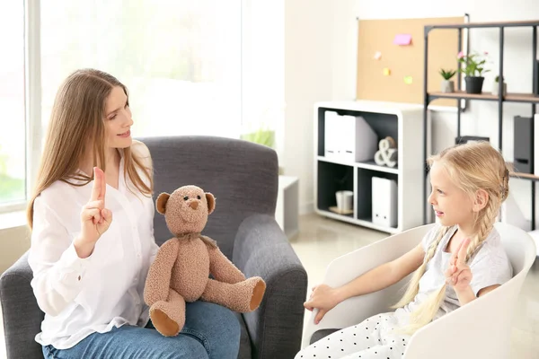 Mother teaching her deaf mute daughter to use sign language at home