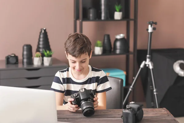 Roztomilá fotografka, co sedí u stolu v profesionálním studiu — Stock fotografie