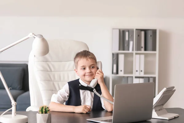 Cute little businessman talking by phone in office — Stock Photo, Image
