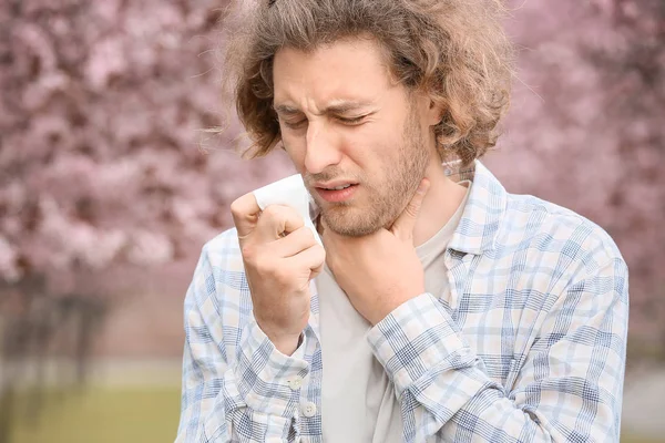 Chory człowiek z wycieraczki nosa w dniu wiosny — Zdjęcie stockowe
