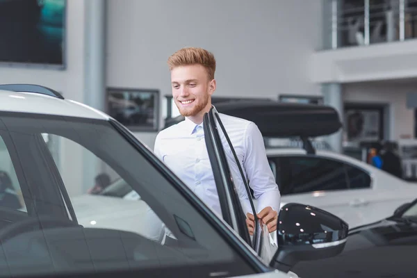 Man choosing new car in salon — Stock Photo, Image