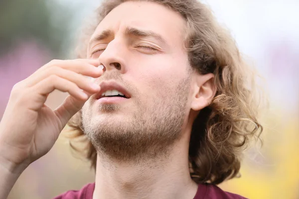 Young man with nasal drops on spring day — Stock Photo, Image