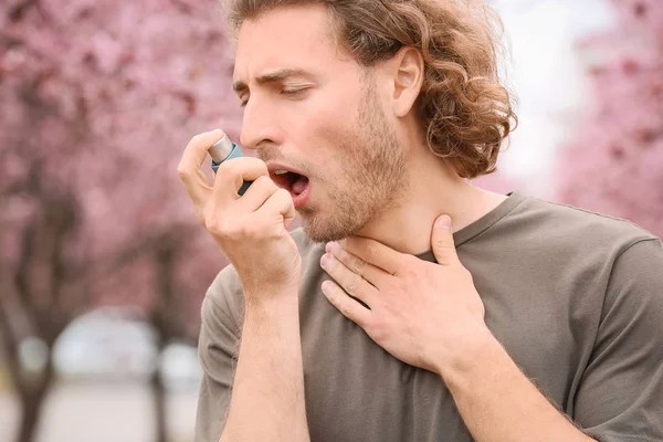Hombre con inhalador que sufre un ataque de asma en el día de primavera — Foto de Stock
