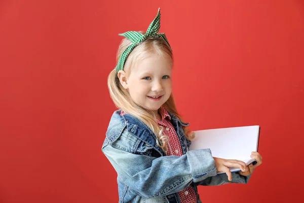 Портрет чарівної маленької дівчинки, що читає книгу на кольоровому фоні — стокове фото